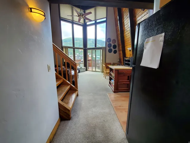Hall with light colored carpet, a high ceiling, and a mountain view