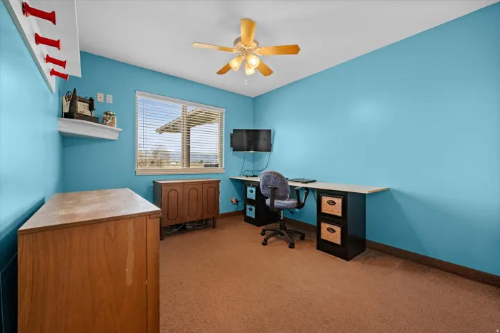 Office space with light carpet and ceiling fan
