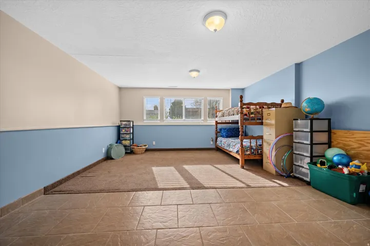 Bedroom with a textured ceiling and stone finish flooring
