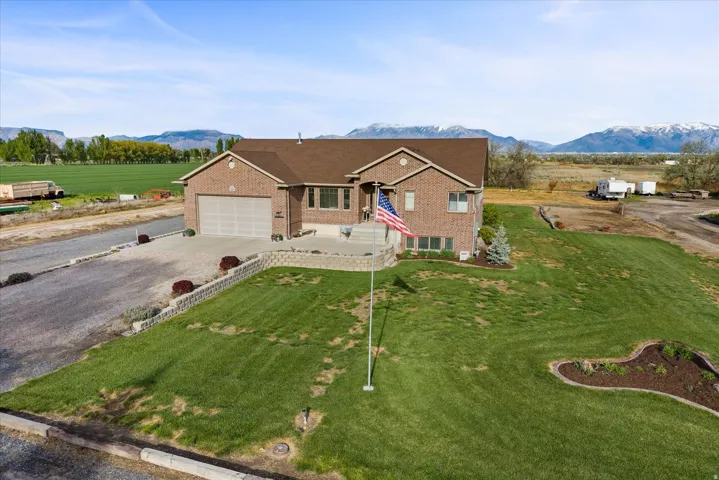 View of front of house with driveway, a front lawn, brick siding, and an attached garage