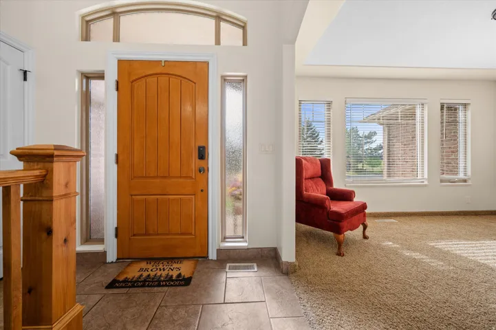 Entryway featuring light carpet and light tile patterned flooring