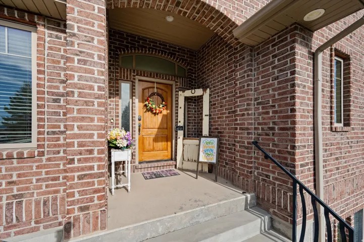 Property entrance featuring brick siding and covered porch