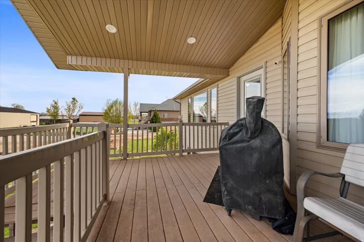 Wooden terrace featuring a grill and a residential view