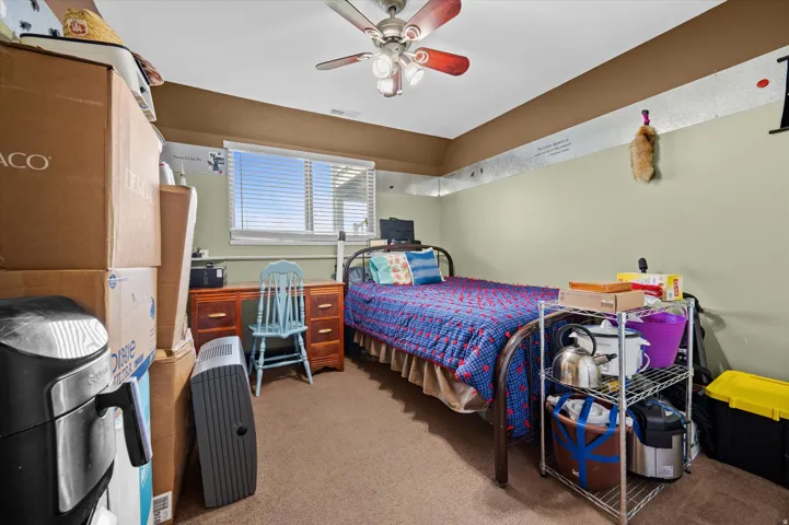Bedroom featuring light carpet and a ceiling fan