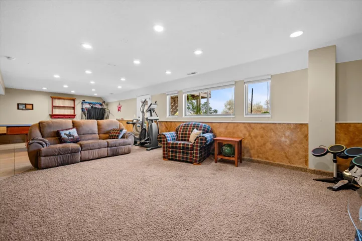 Living area with carpet, a wainscoted wall, and recessed lighting