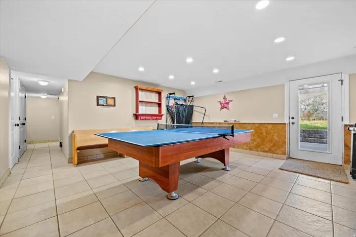 Game room featuring light tile patterned flooring, wainscoting, and recessed lighting