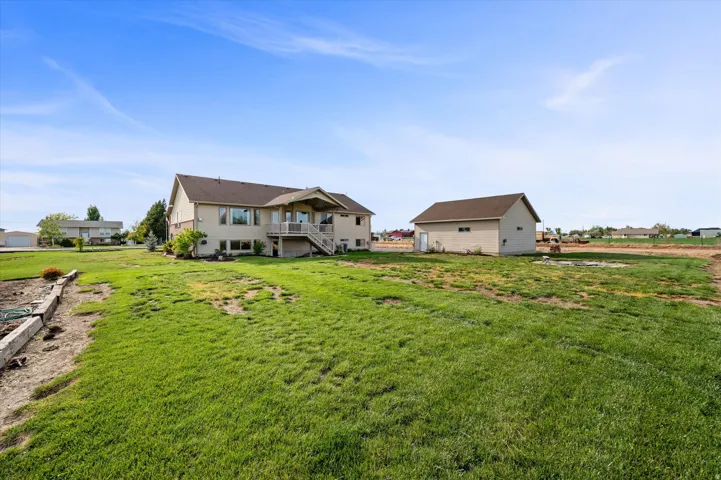 Back of house with a lawn and a balcony