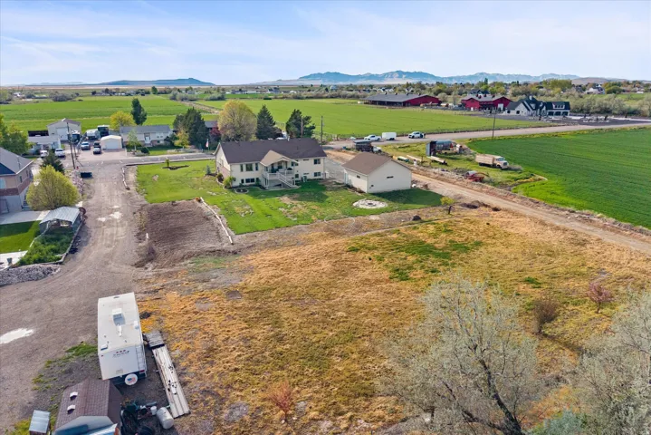 Aerial view of sparsely populated area featuring nearby suburban area and mountains