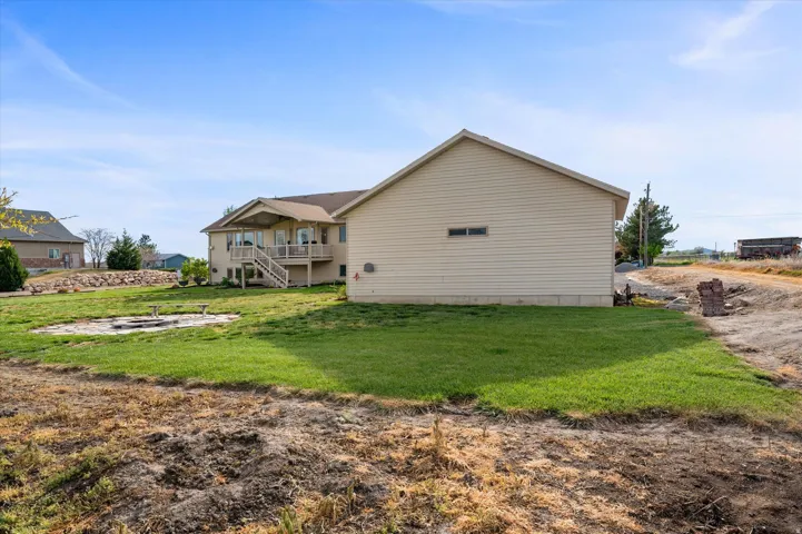 View of property exterior with a lawn, a fire pit, and a patio area