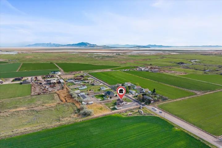 Aerial overview of property's location with rural landscape, rows of crops, and a mountain backdrop