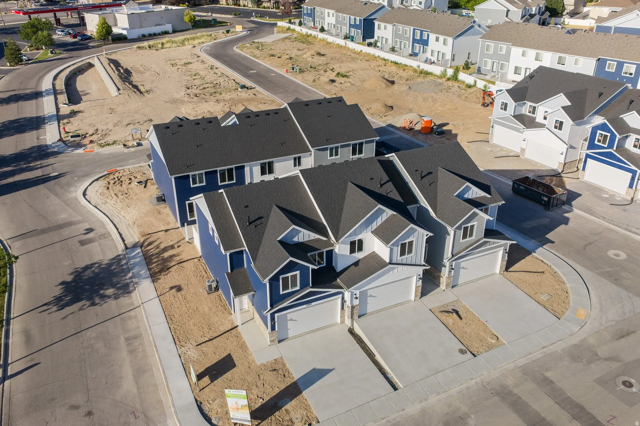 New construction townhomes featuring modern exteriors with blue and gray siding