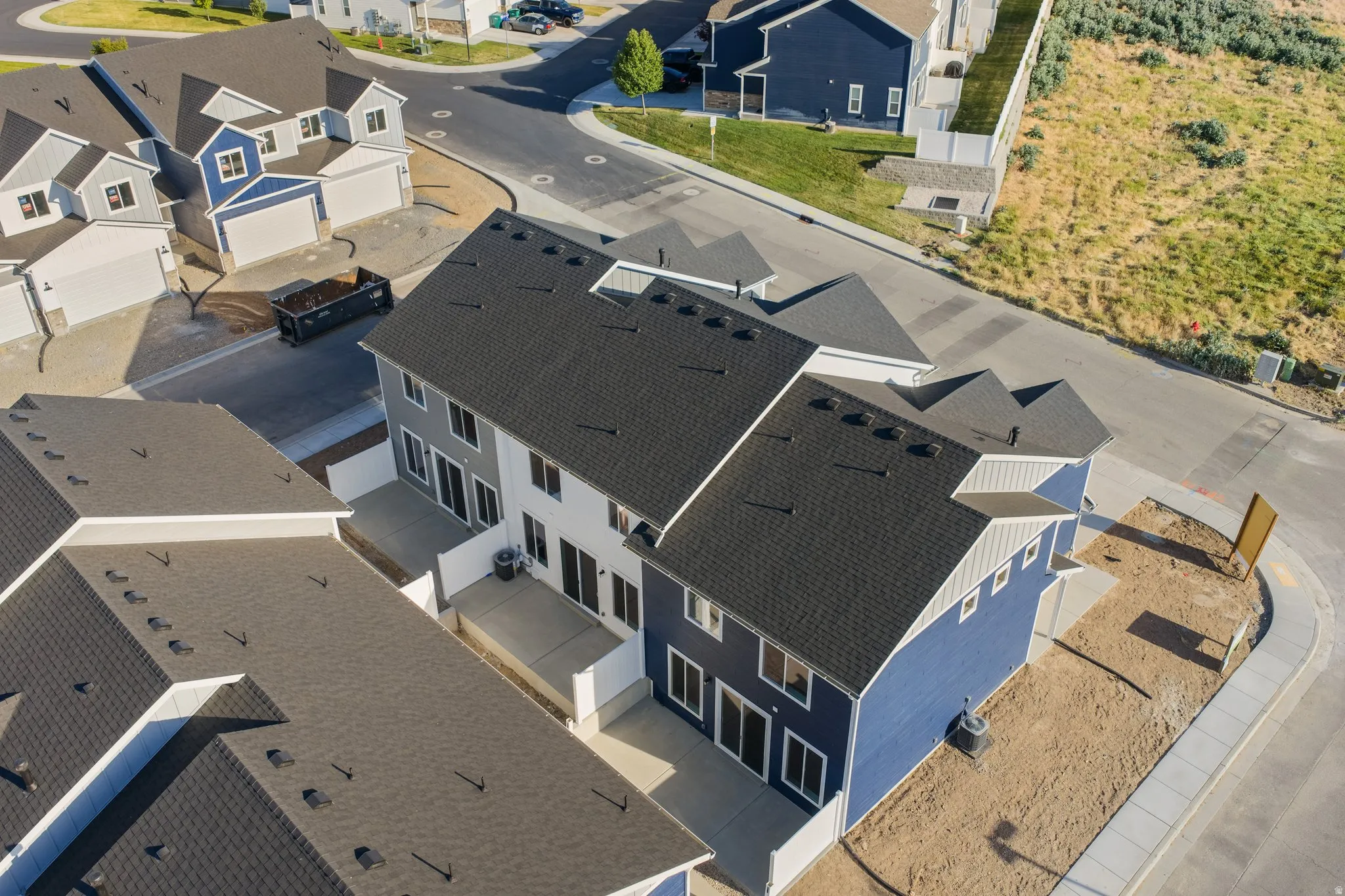 Newly constructed multi-level residence featuring a dark shingle roof and blue and gray siding