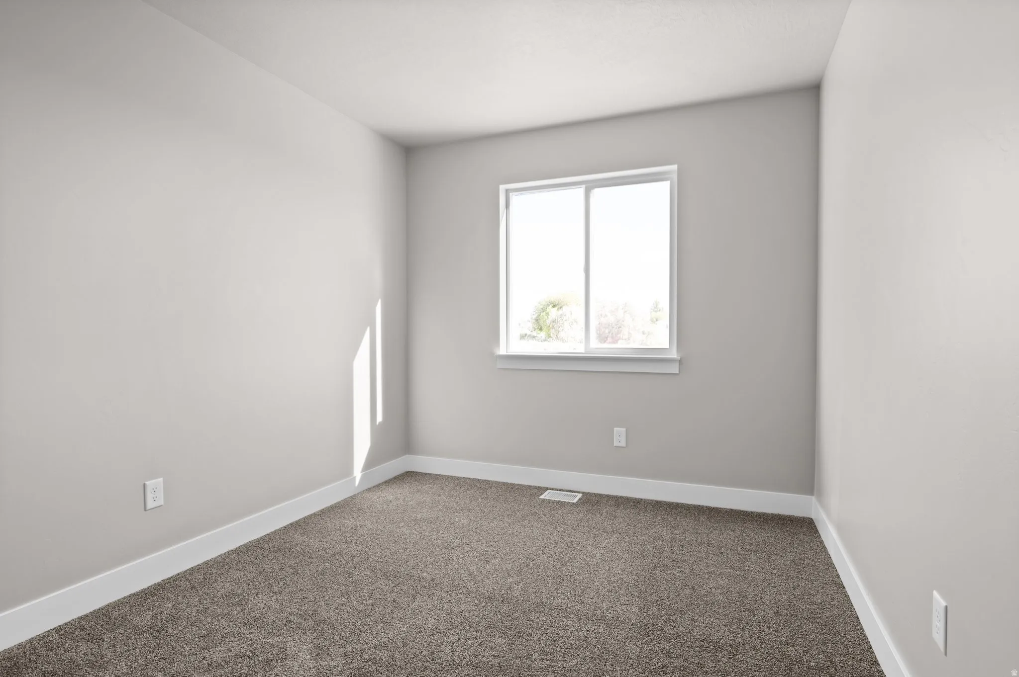 Bedroom featuring neutral gray walls, bright white trim, and a window with white casing