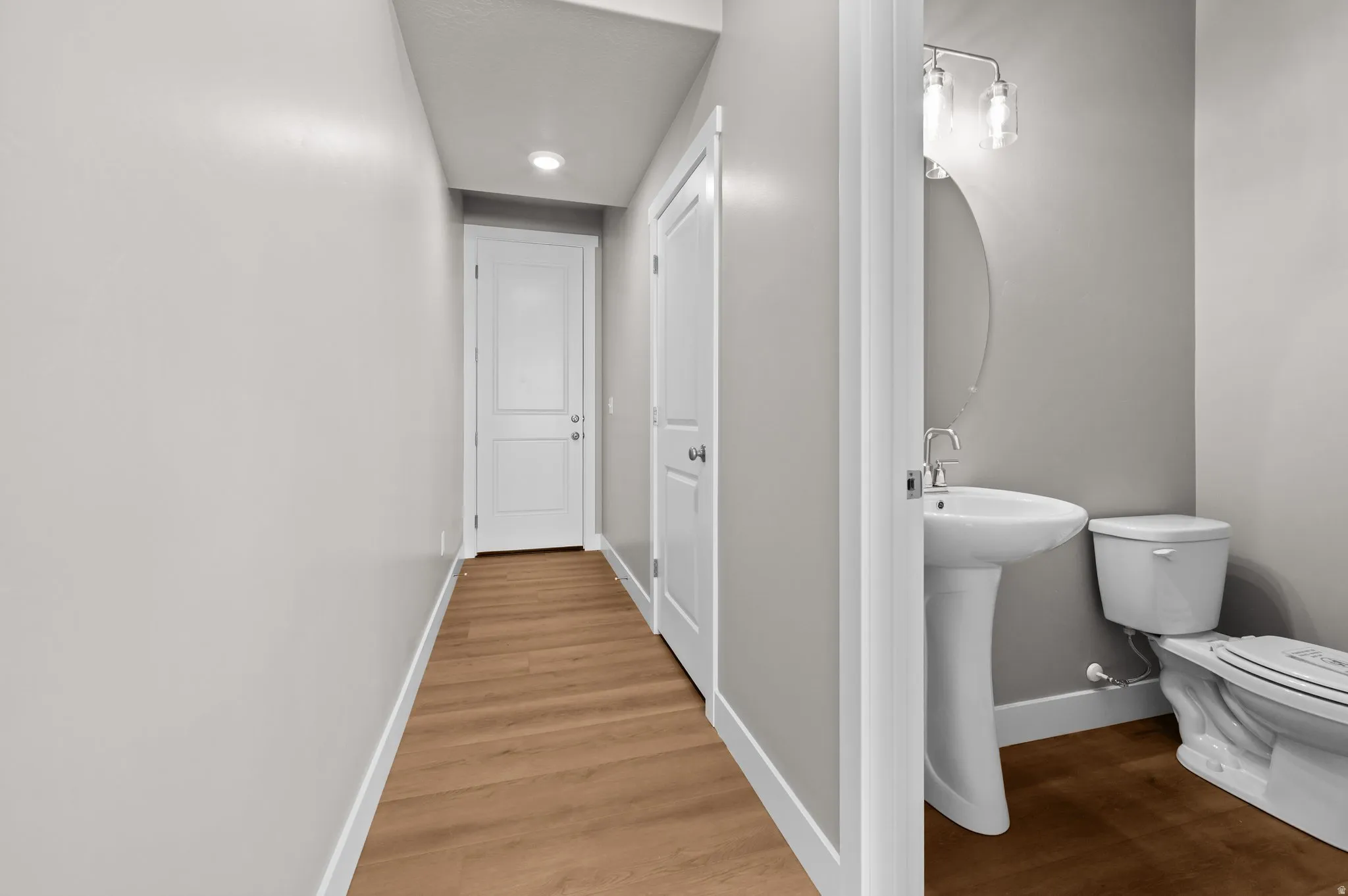 Hallway with wood-finish flooring and recessed lighting