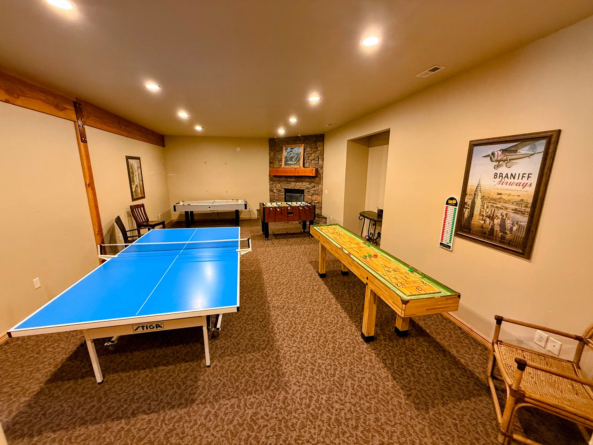 Rec room with a fireplace, dark colored carpet, and recessed lighting