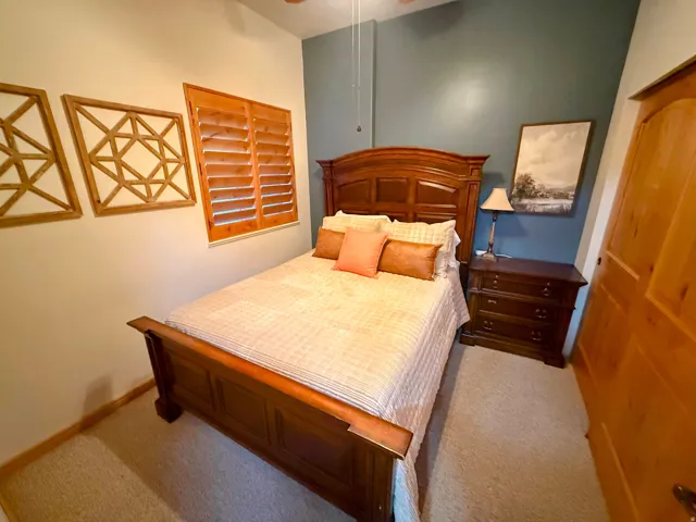 Carpeted bedroom featuring a ceiling fan