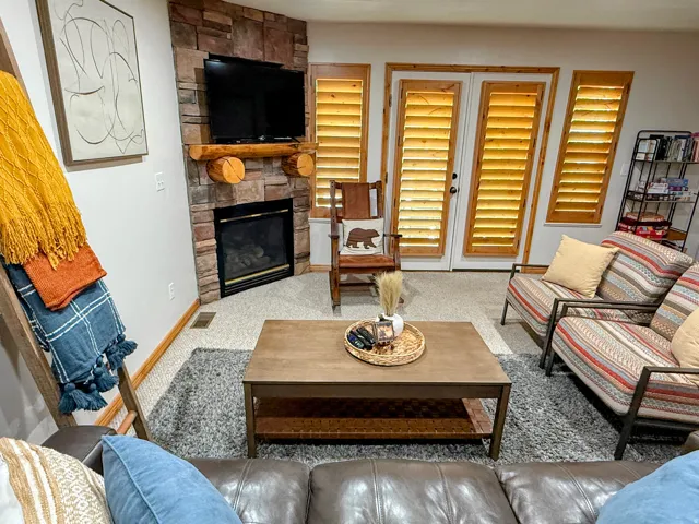 Carpeted living room featuring a fireplace and baseboards