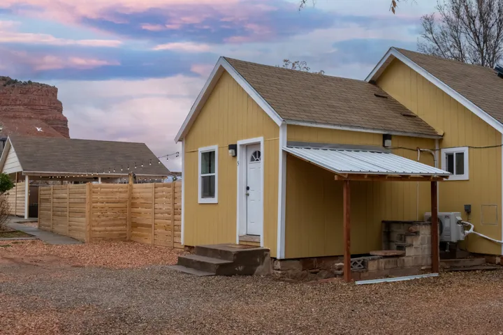 The side of building 2. This unit has 1 unit and an attached garage that has a full bathroom, half bathroom, and laundry hookups. There is extra stroage space under building 2 which the stairs show on the right of the building.