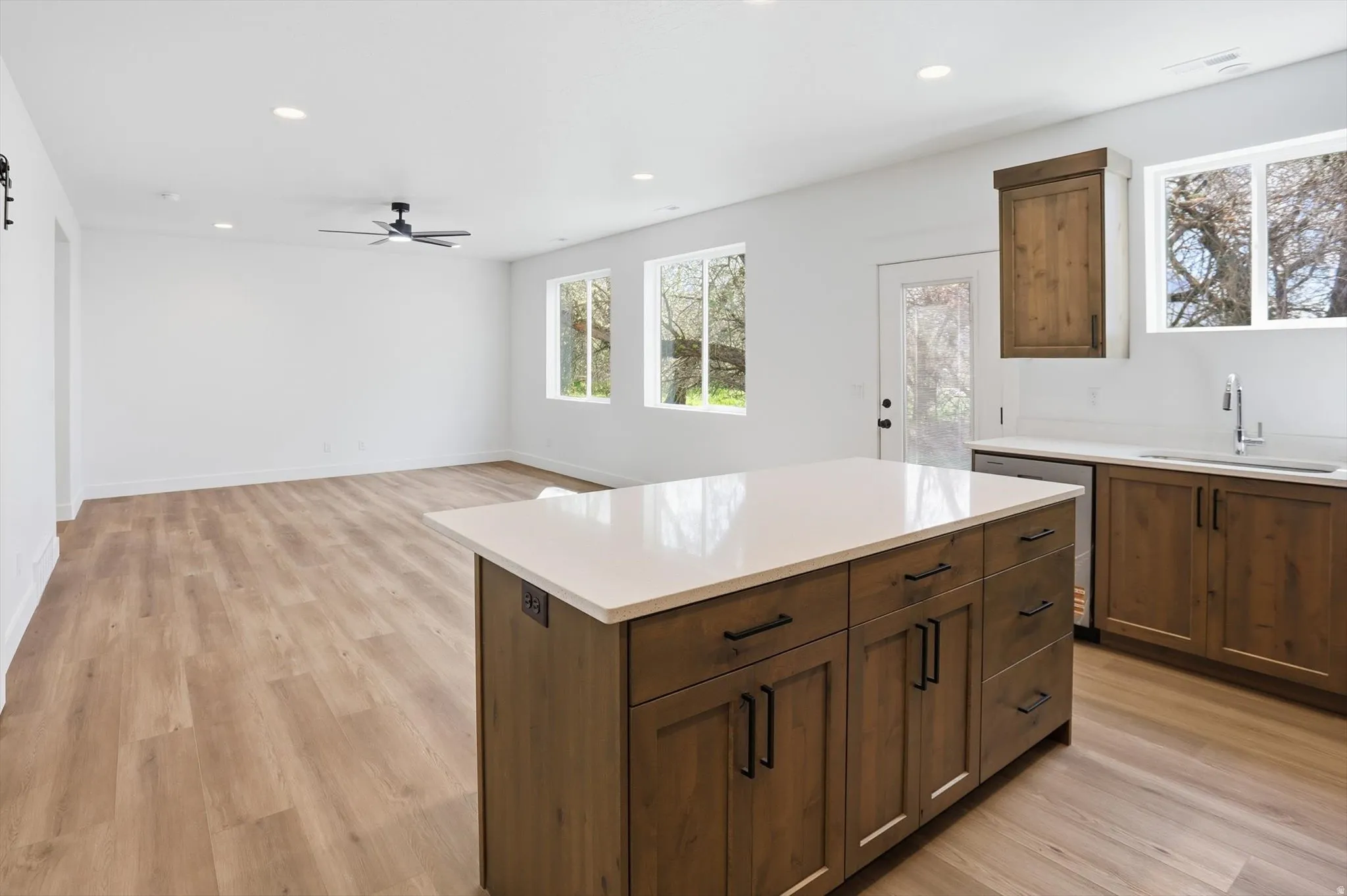 Kitchen with a center island, light wood-type flooring, recessed lighting, a barn door, and dishwasher