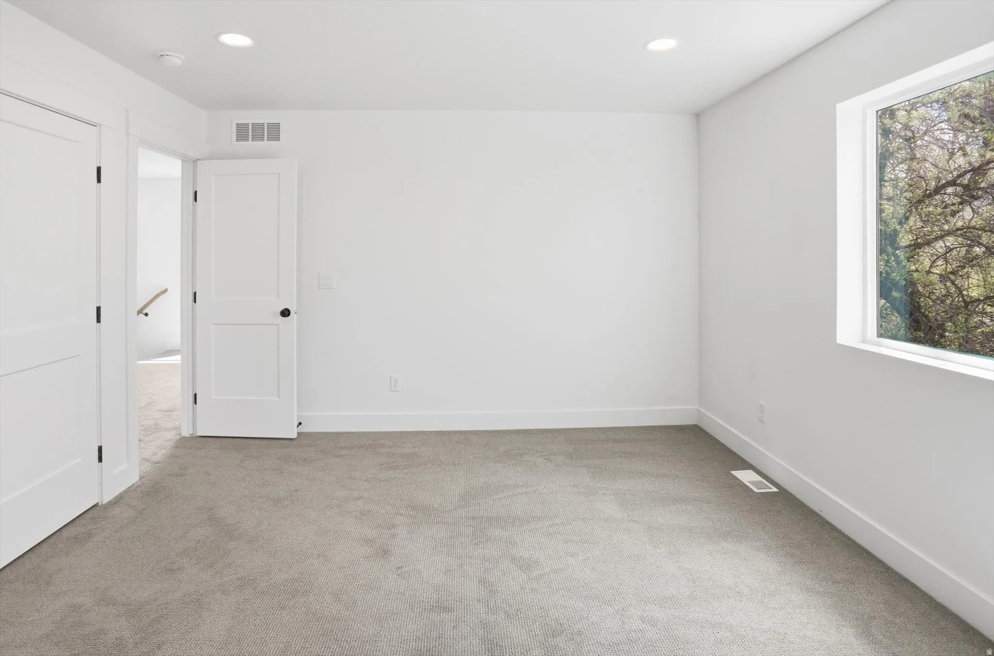 Empty room featuring light colored carpet and recessed lighting