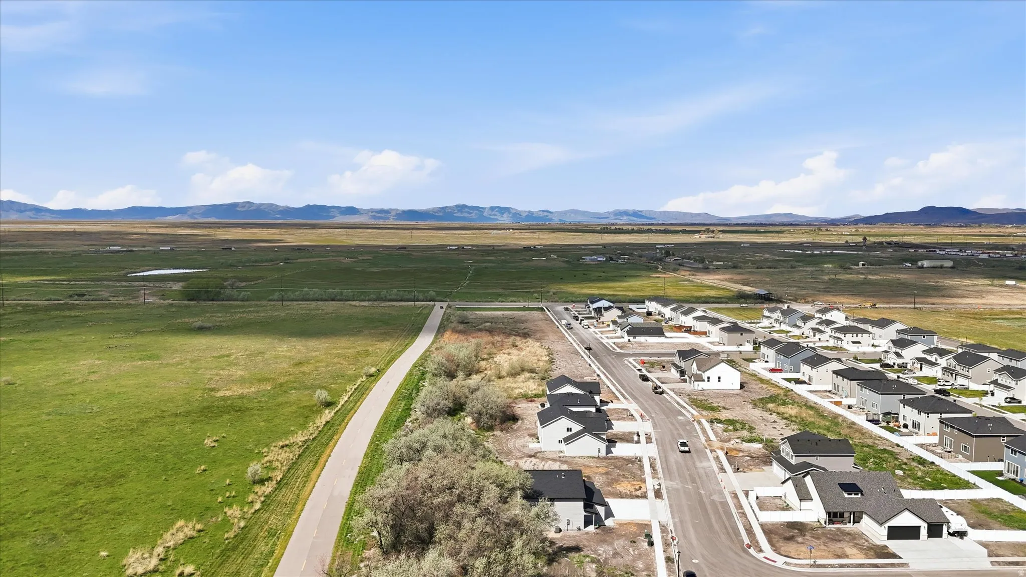 Aerial view of sparsely populated area featuring nearby suburban area and a mountain backdrop