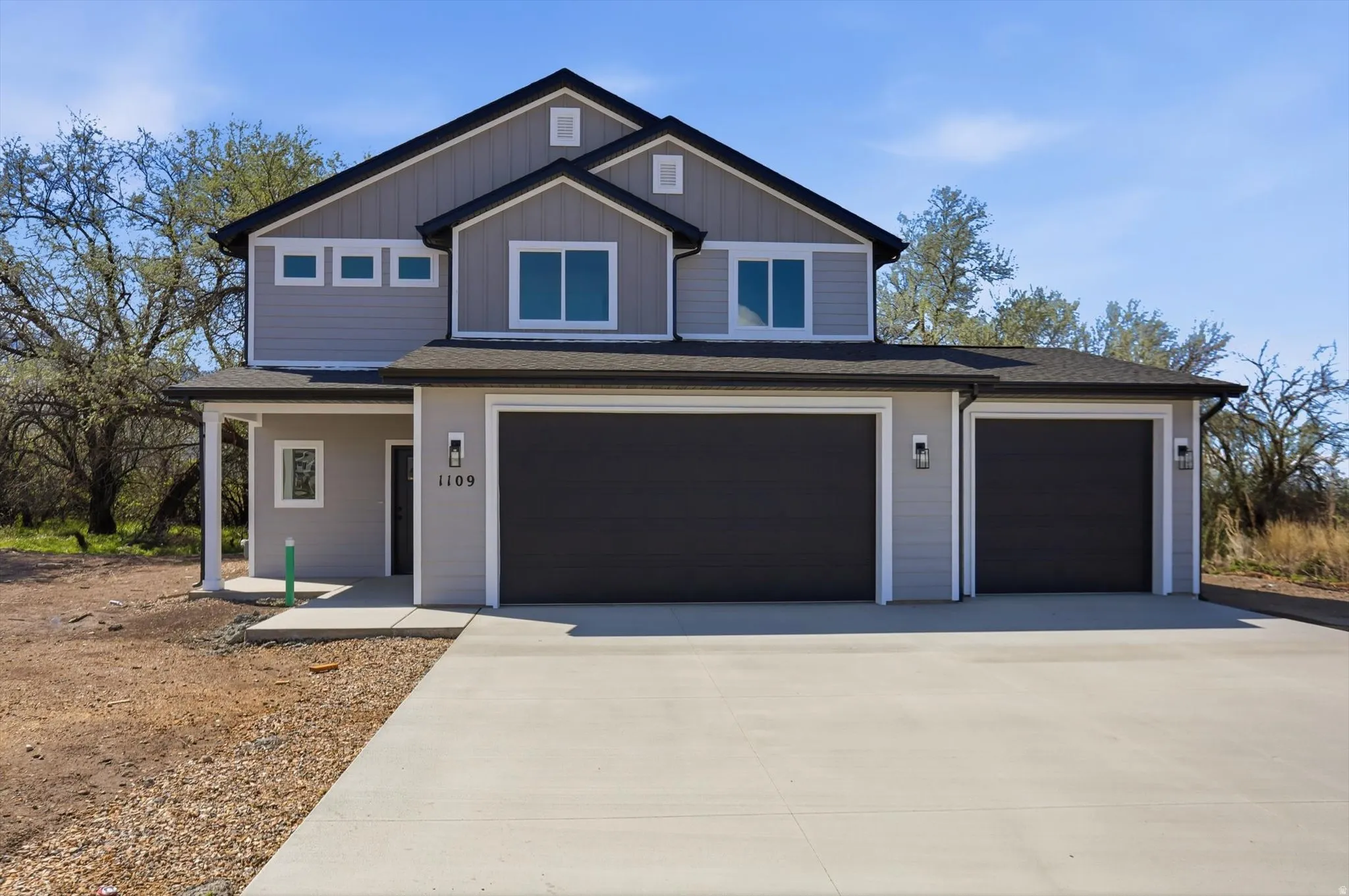 View of front of home featuring driveway, an attached garage, and roof with shingles