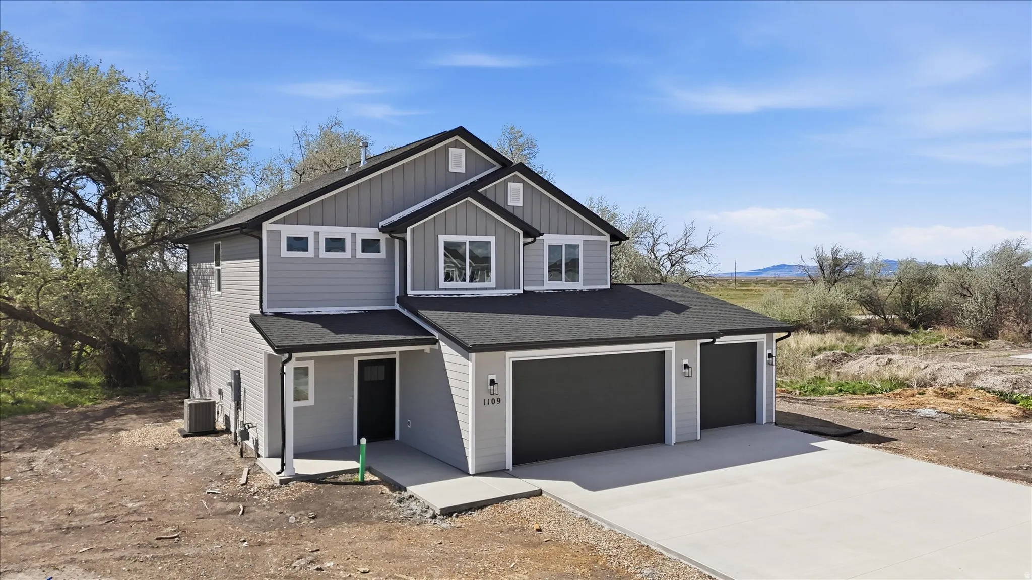 View of front of house featuring driveway, roof with shingles, board and batten siding, and an attached garage