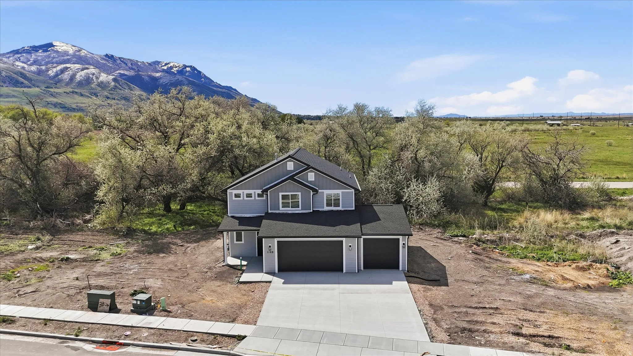 View of front of home featuring driveway, an attached garage, roof with shingles, and a mountain view