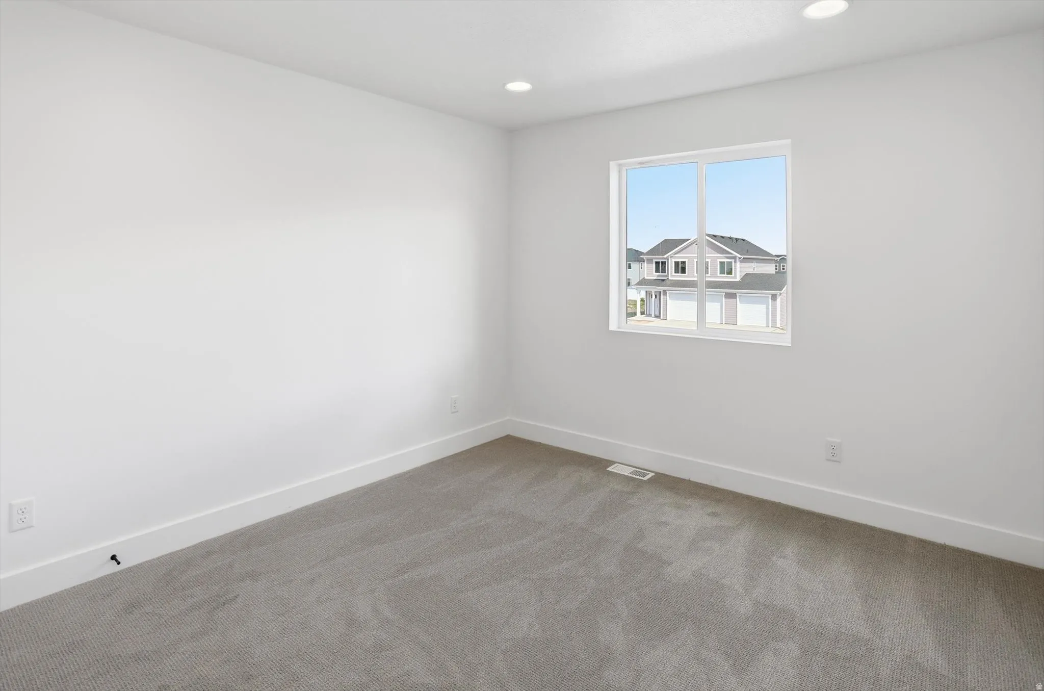 Carpeted empty room featuring baseboards and recessed lighting