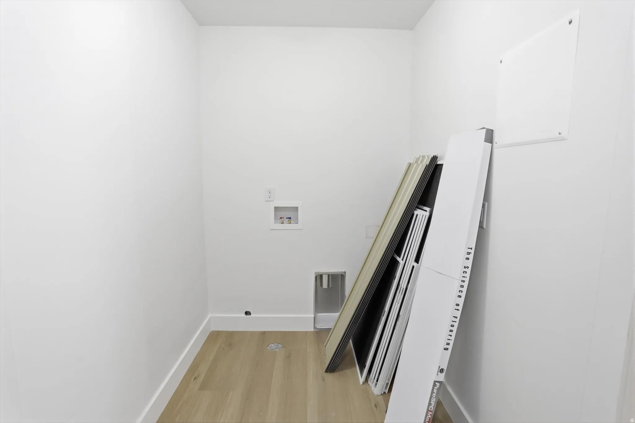 Laundry room with washer hookup and light wood finished floors
