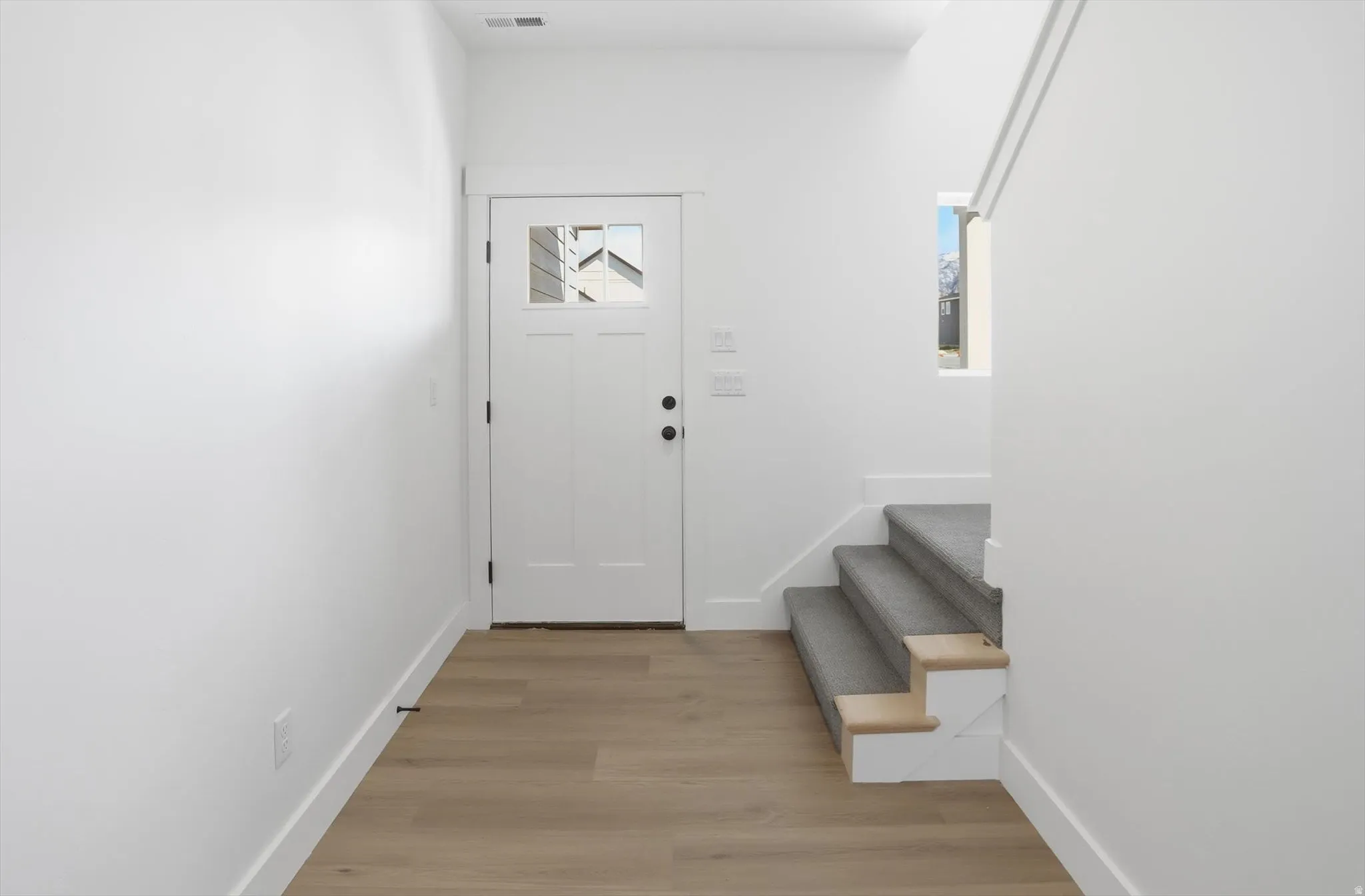 Entryway featuring baseboards and light wood finished floors