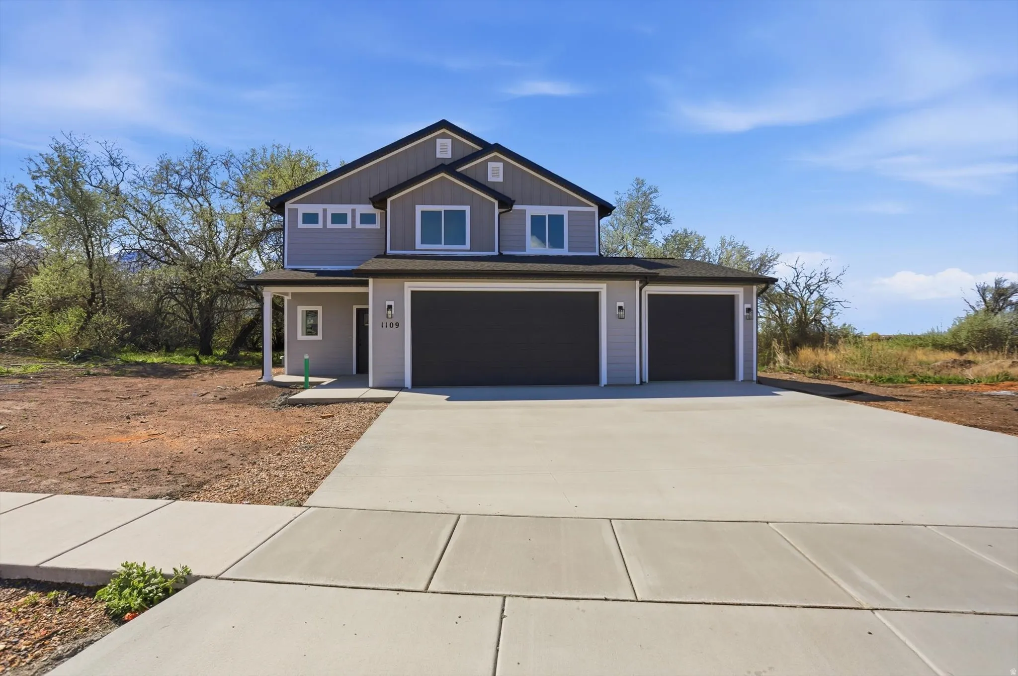 View of front of house featuring driveway, an attached garage, and a porch