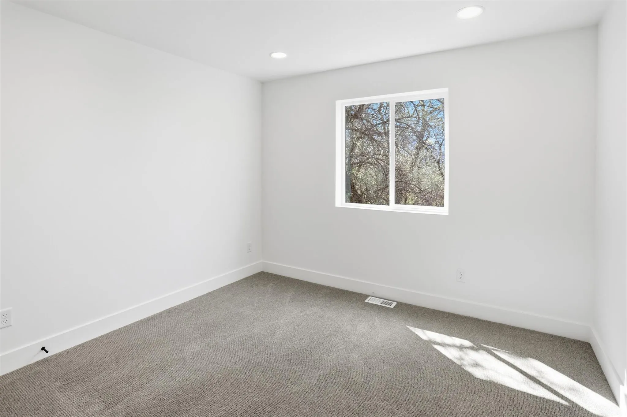 Carpeted empty room with baseboards and recessed lighting