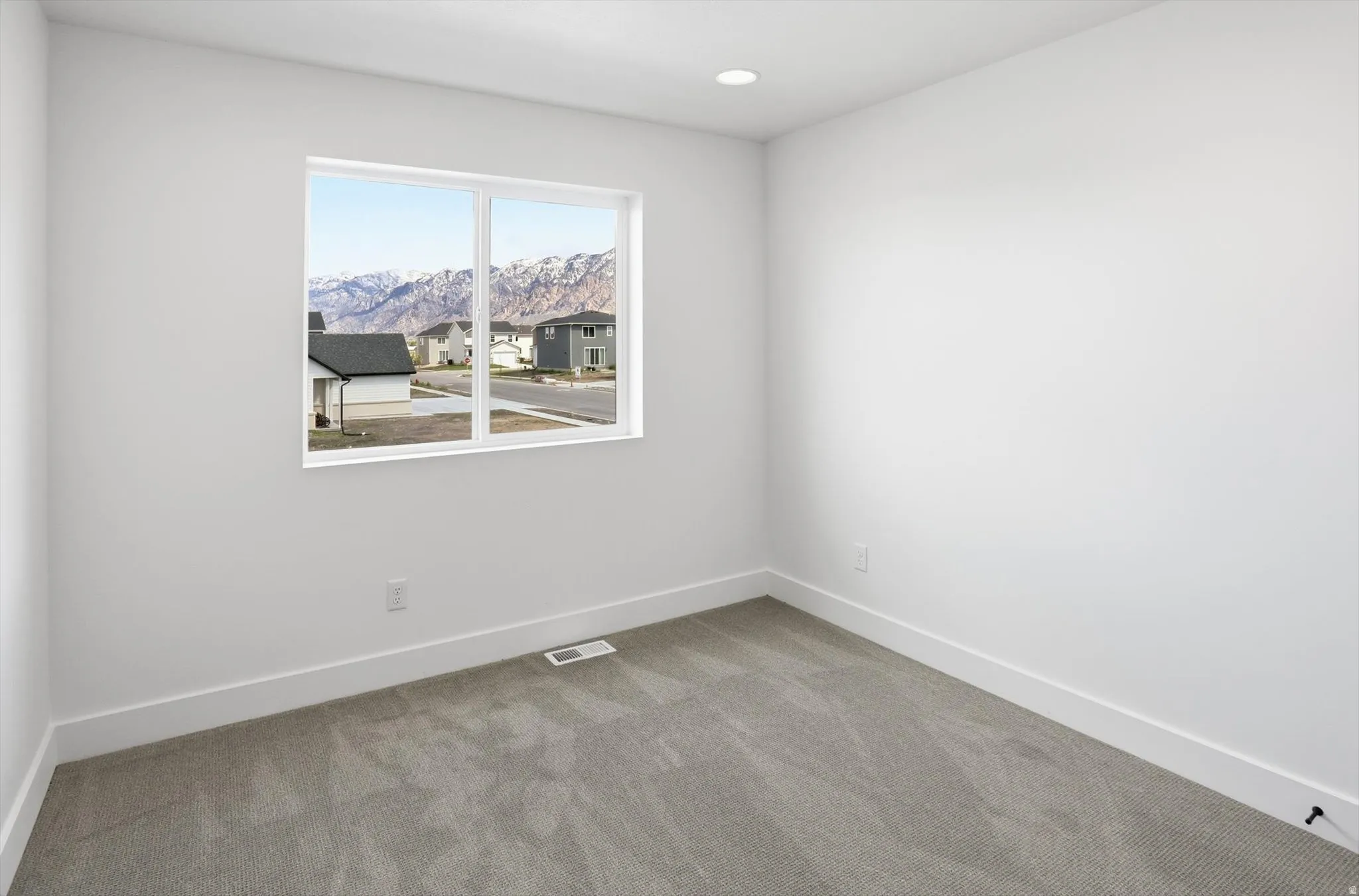 Carpeted spare room featuring a mountain view and recessed lighting