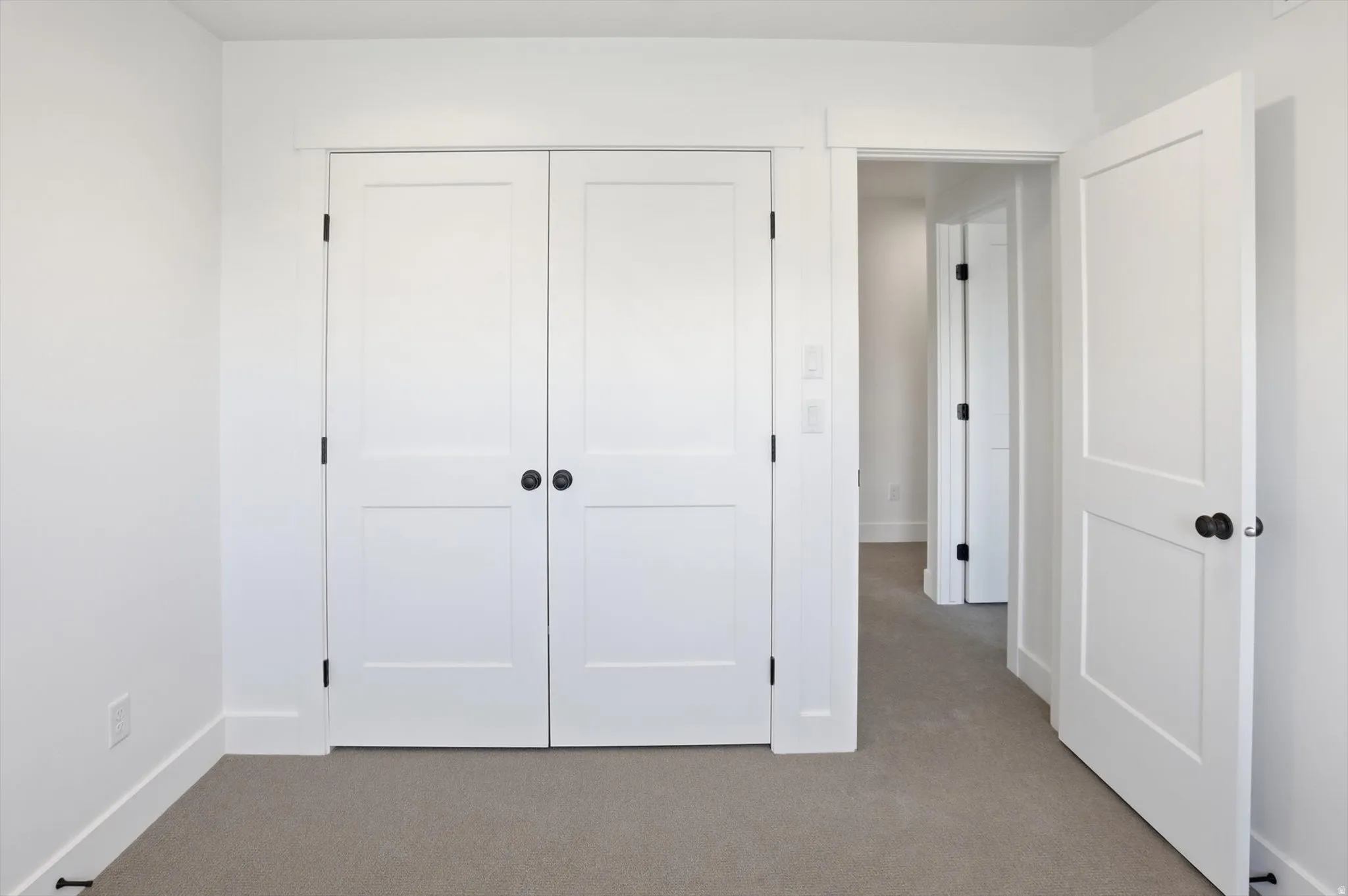 Unfurnished bedroom with light carpet and a closet