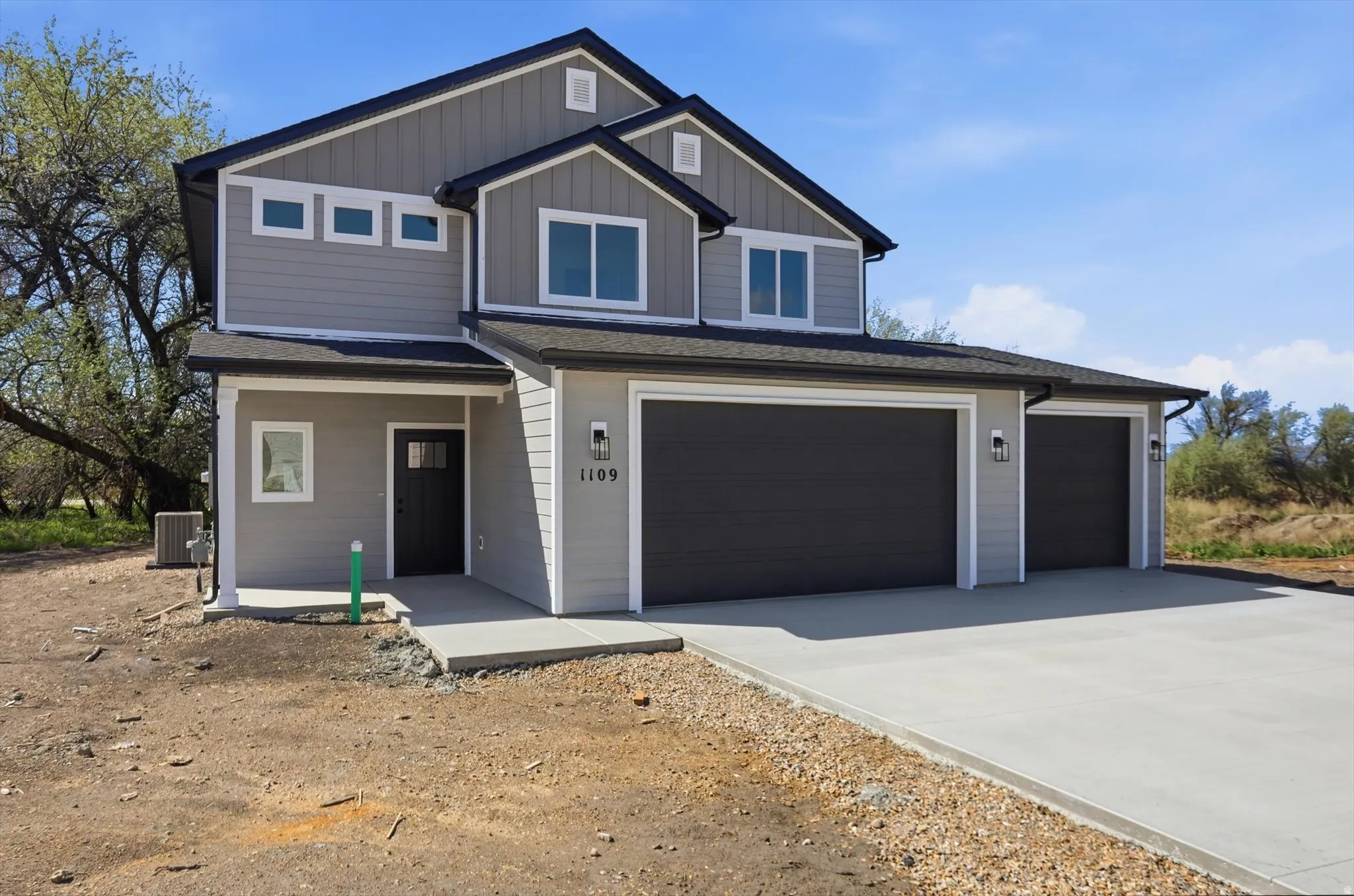 View of front facade with concrete driveway, a shingled roof, a garage, and board and batten siding