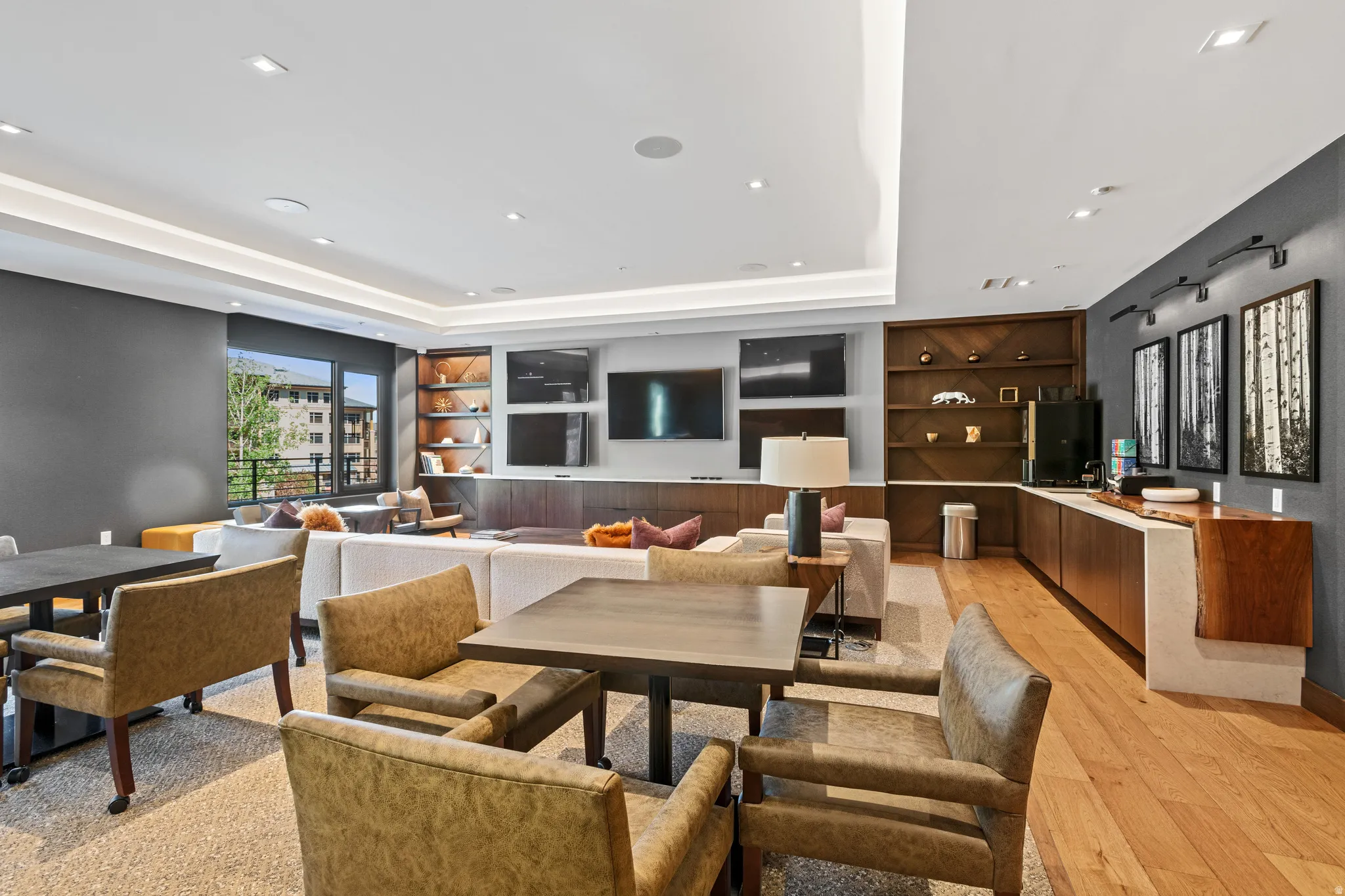 Dining room with built in shelves, a raised ceiling, and light wood-style flooring