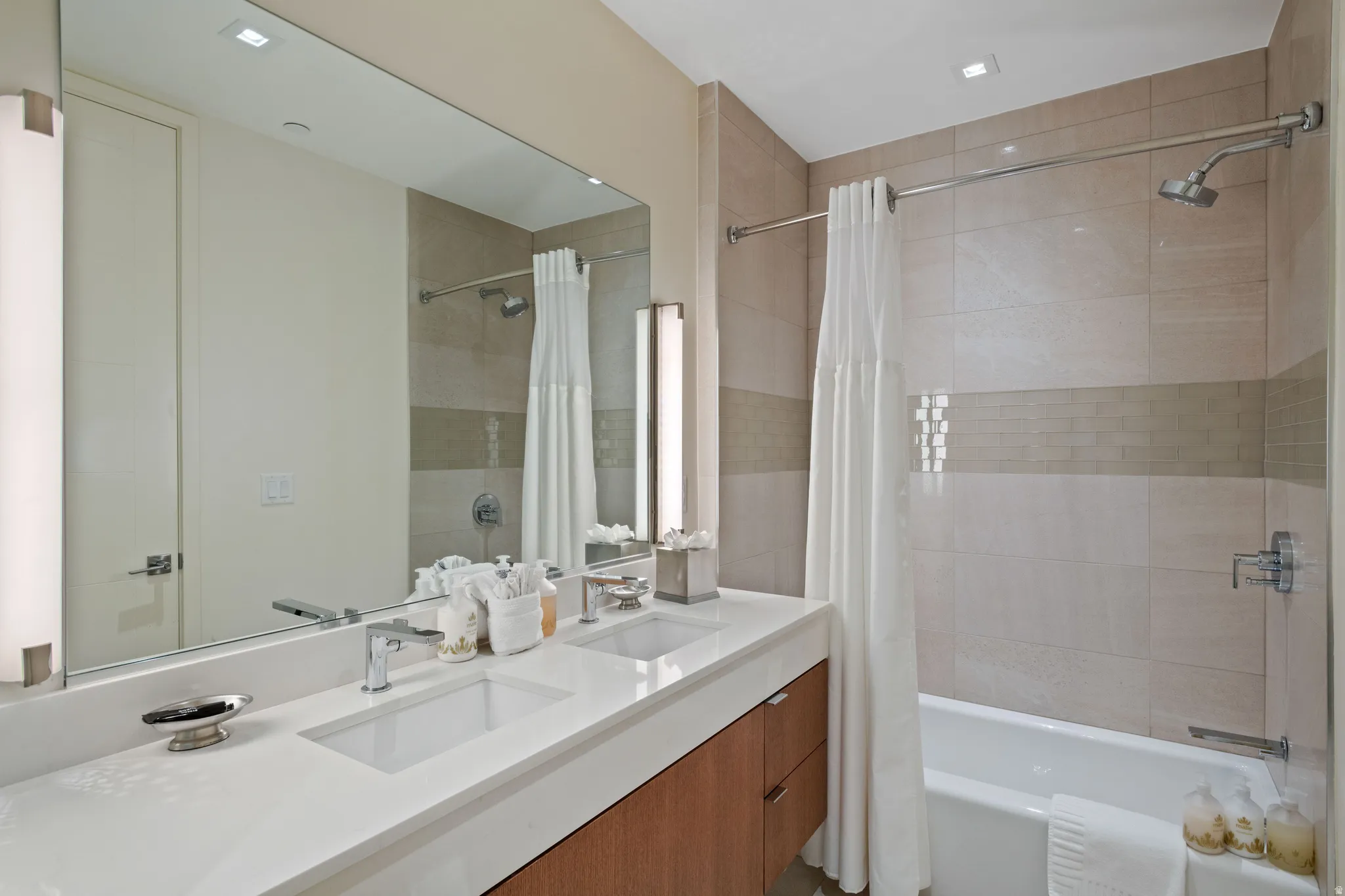 Full bathroom featuring double vanity and shower / tub combo