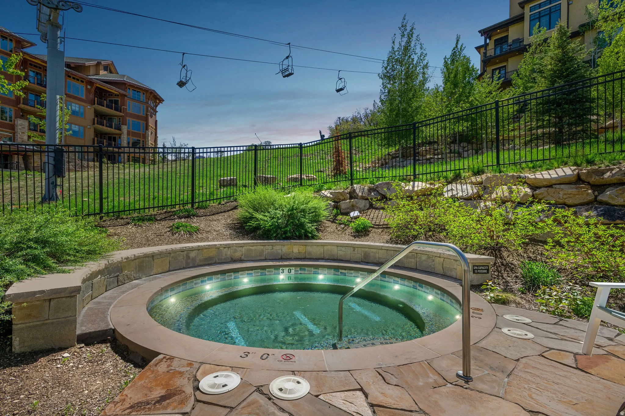View of swimming pool featuring a hot tub and patio surround