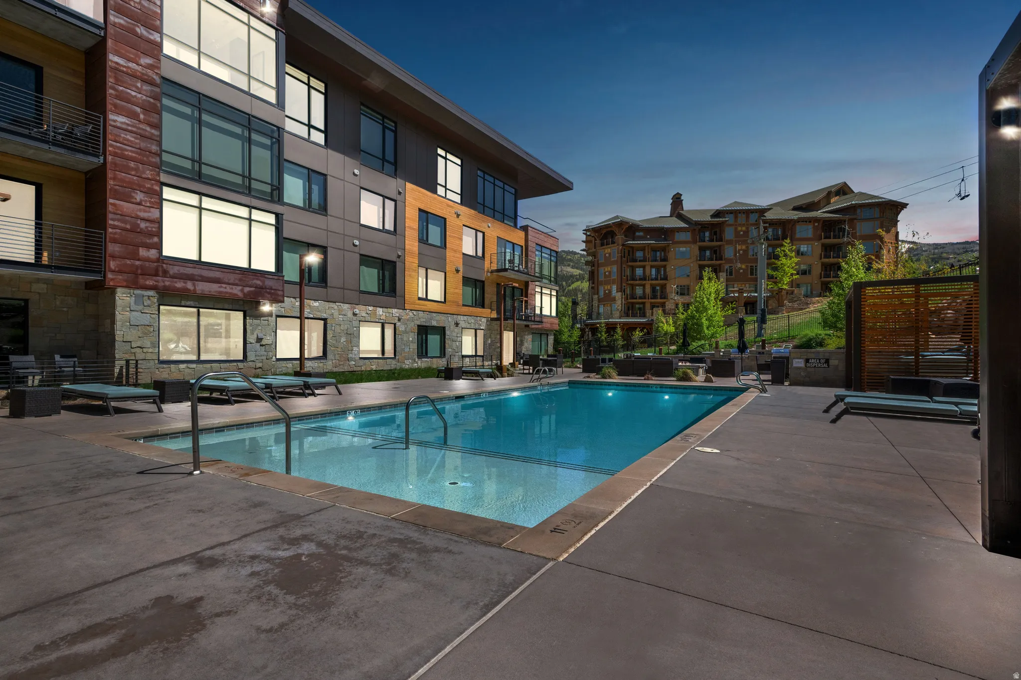 Pool at dusk with a community pool and a patio