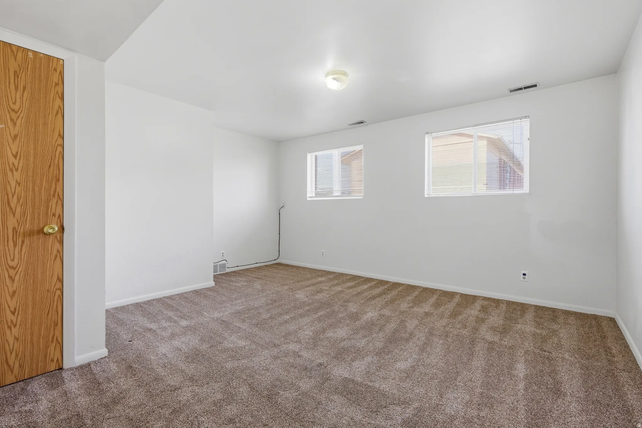 Spare room featuring baseboards and carpet flooring