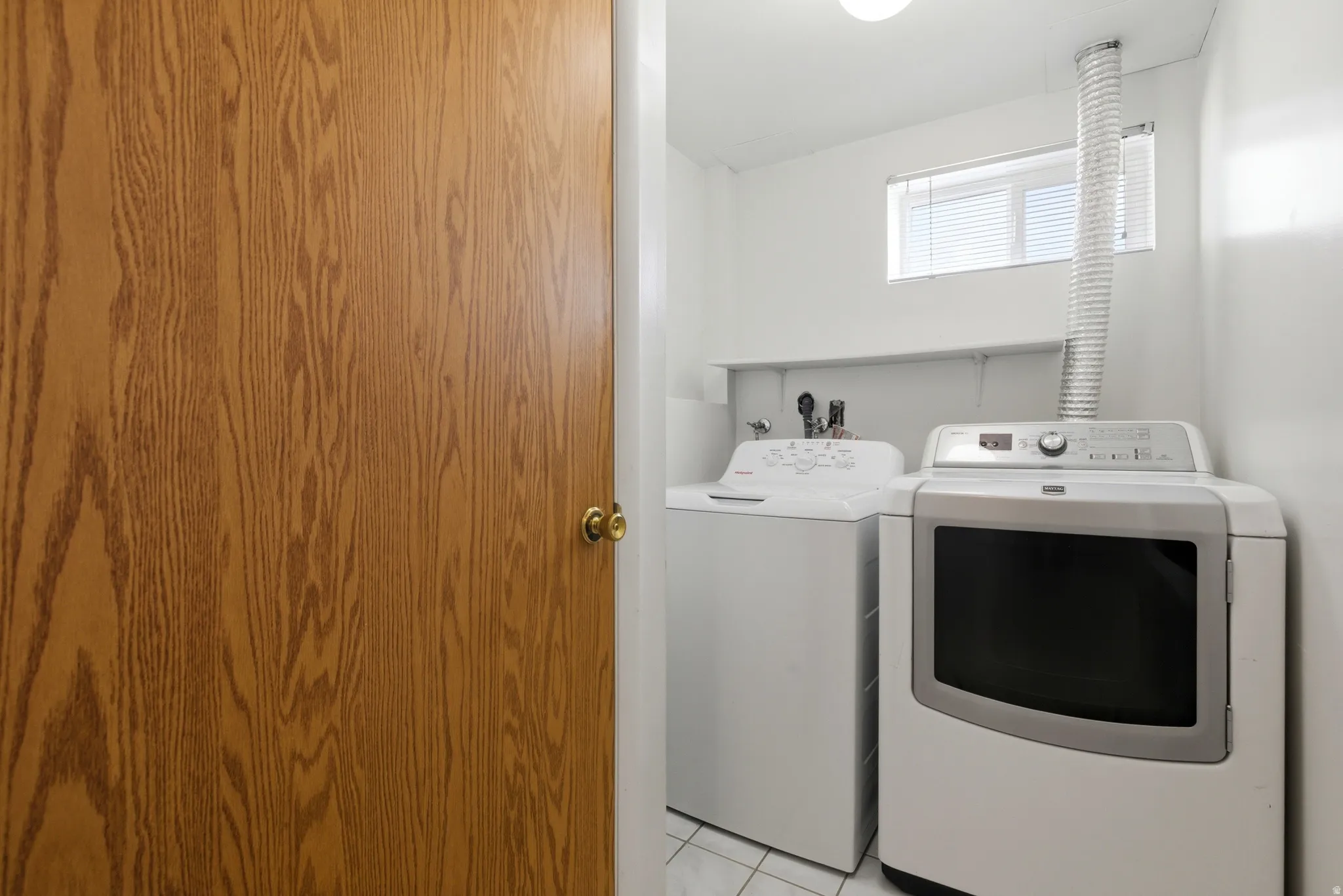 Laundry area featuring washer and dryer and light tile patterned flooring