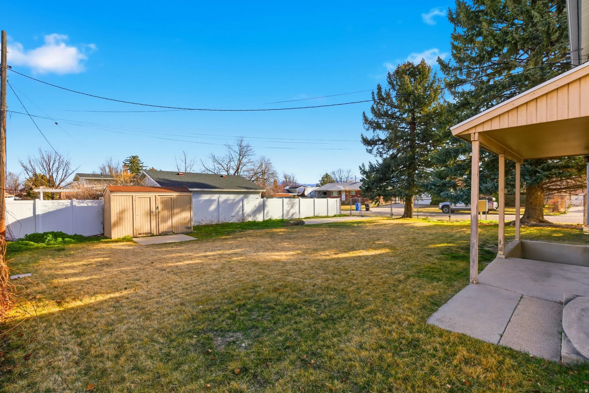 Fenced backyard with a storage shed and a patio area