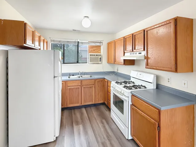 Kitchen featuring white appliances, light wood-style flooring, and wood finish cabinets