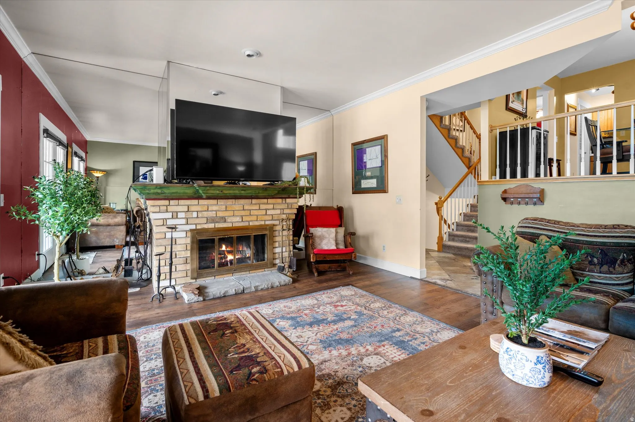 Spacious family room featuring french doors, LVP flooring, crown molding, and wood fireplace.