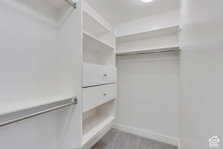 Custom closet system with multiple shelving units, integrated drawers, and chrome hanging rods