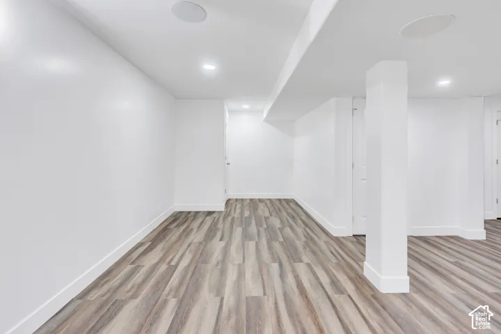 Spacious room featuring wood-finish flooring, recessed lighting, and integrated ceiling speakers