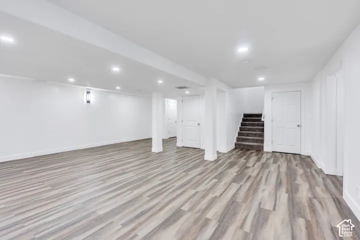 Spacious open-concept room featuring wood-finish flooring and recessed lighting