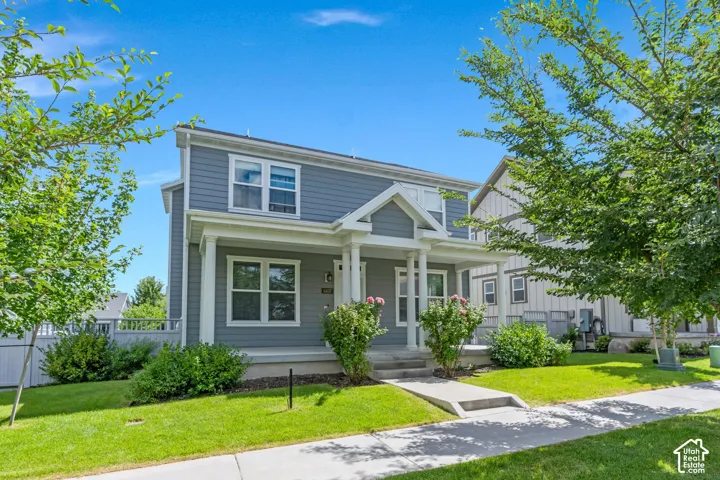 Two-story residence featuring a covered front porch, horizontal siding, and white trim