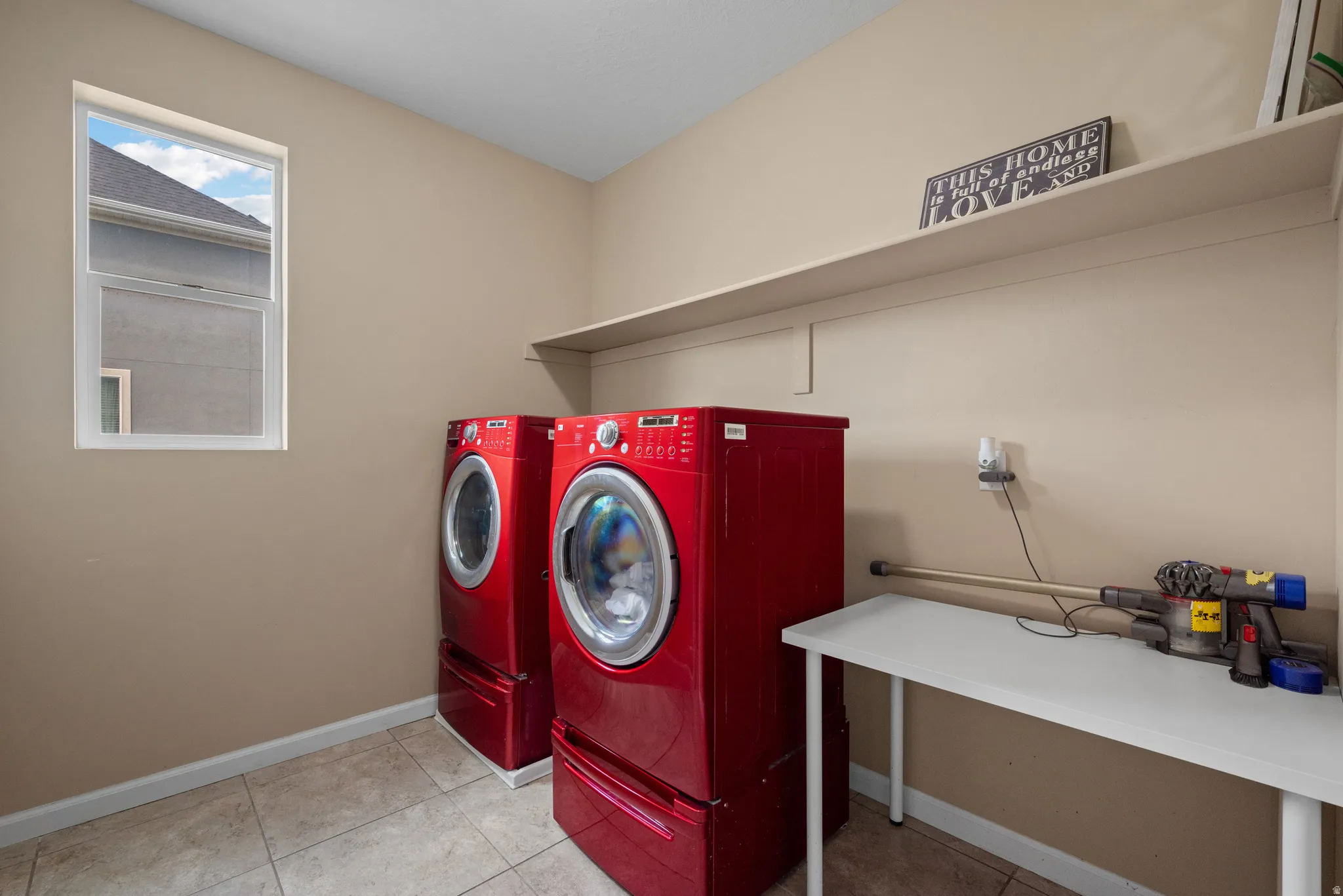 Laundry room with washer and dryer and light tile patterned flooring